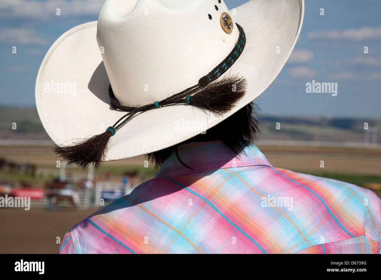 A woman in a cowboy hat watches the rodeo Stock Photo