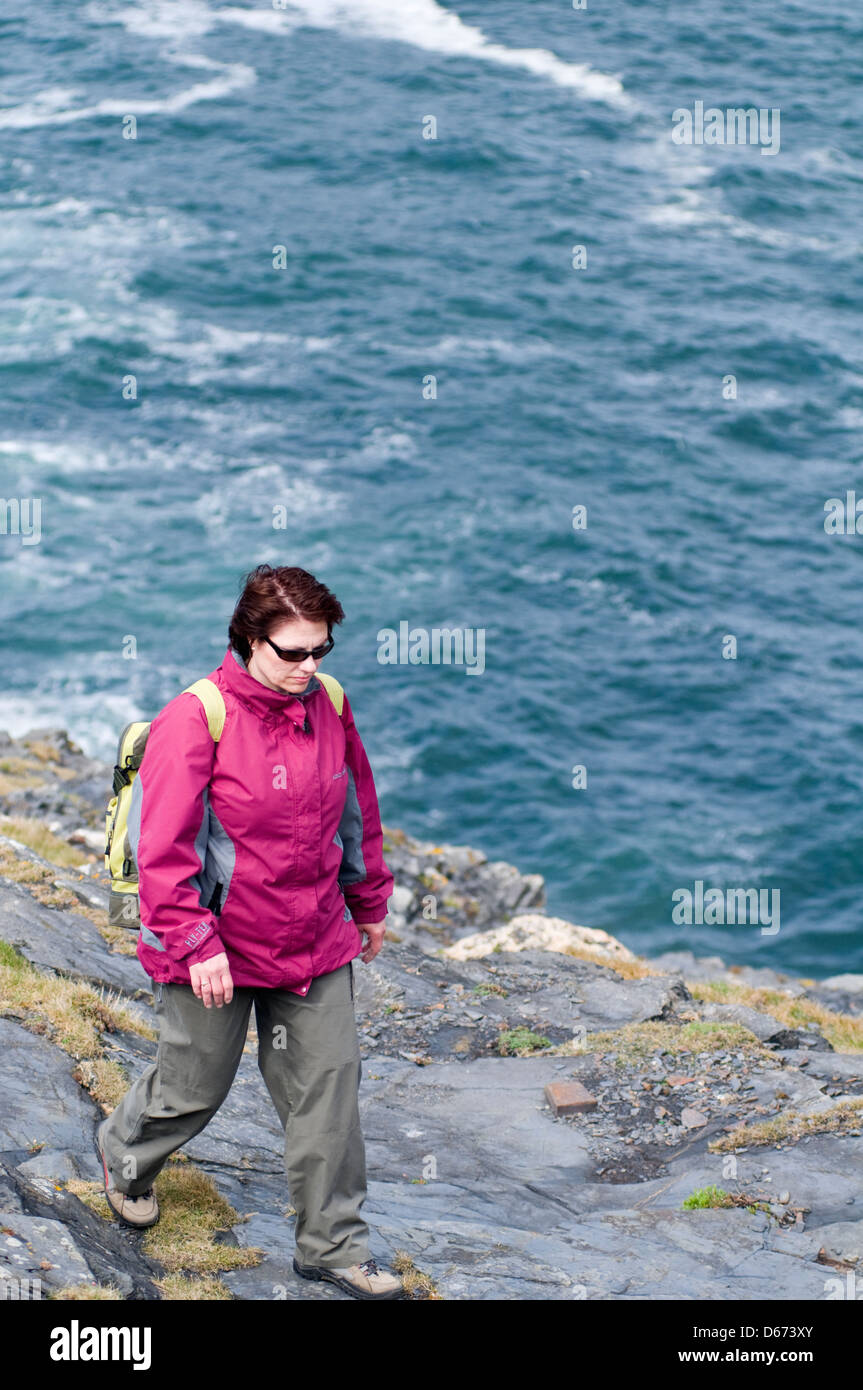 A woman hiking along the coast in north Cornwall, England, UK Stock Photo