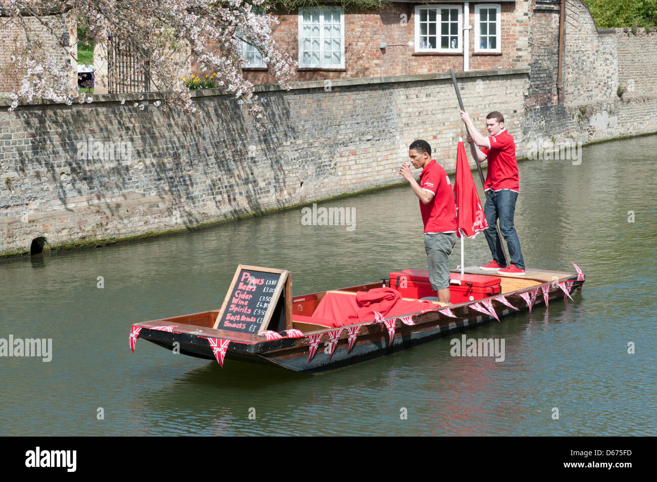 Cambridge, UK. 14 April 2013. A colourfully decorated punt sells drinks and snacks on the River Cam. The river was busy with tourists enjoying the warmest day of the year so far with temperatures hitting 20 degrees centigrade. Spring weather finally arrived after weeks of cold wet weather. Stock Photo