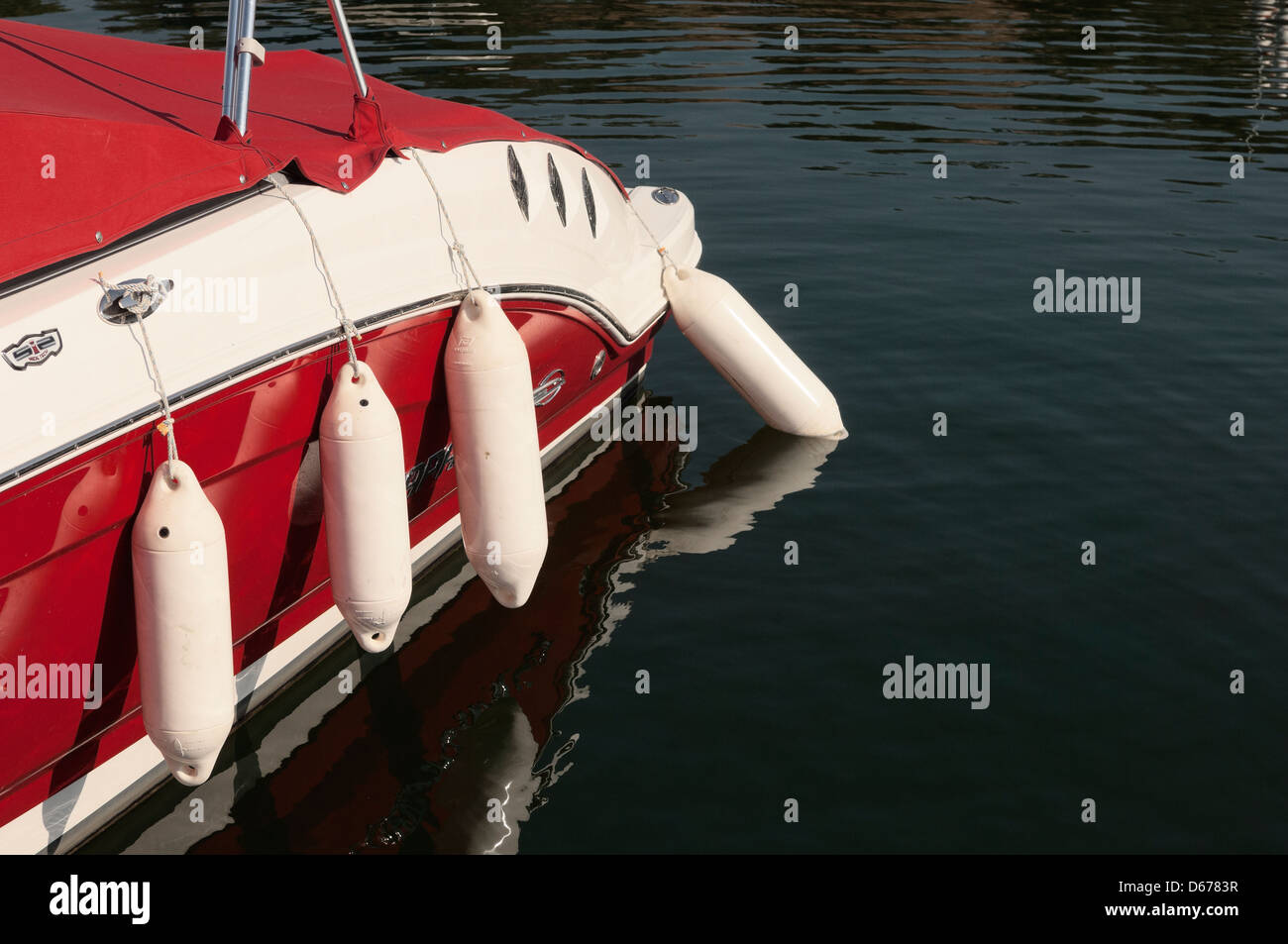 Fenders hanging in the side of a moored Chaparral motorboat Stock Photo