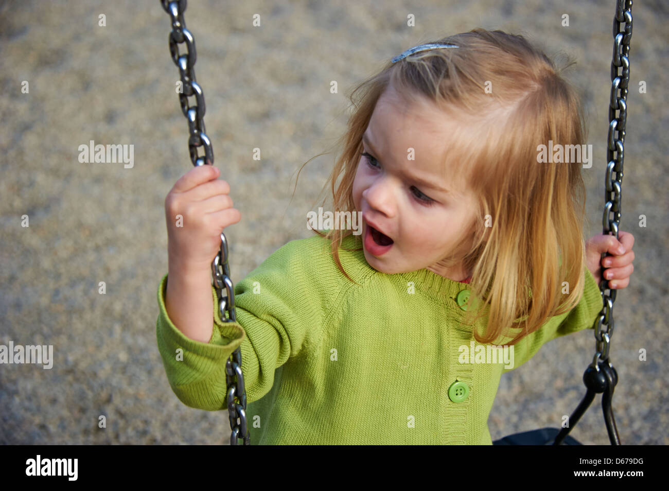 Baby child toddler blond girl on the swing - seesaw Stock Photo
