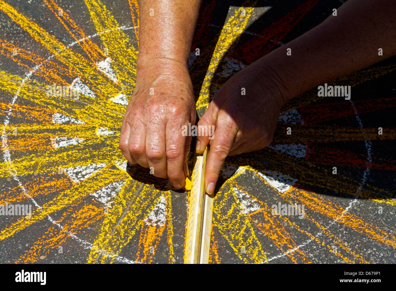 Closeup of artist's hands using a ruler to make a design on the ...