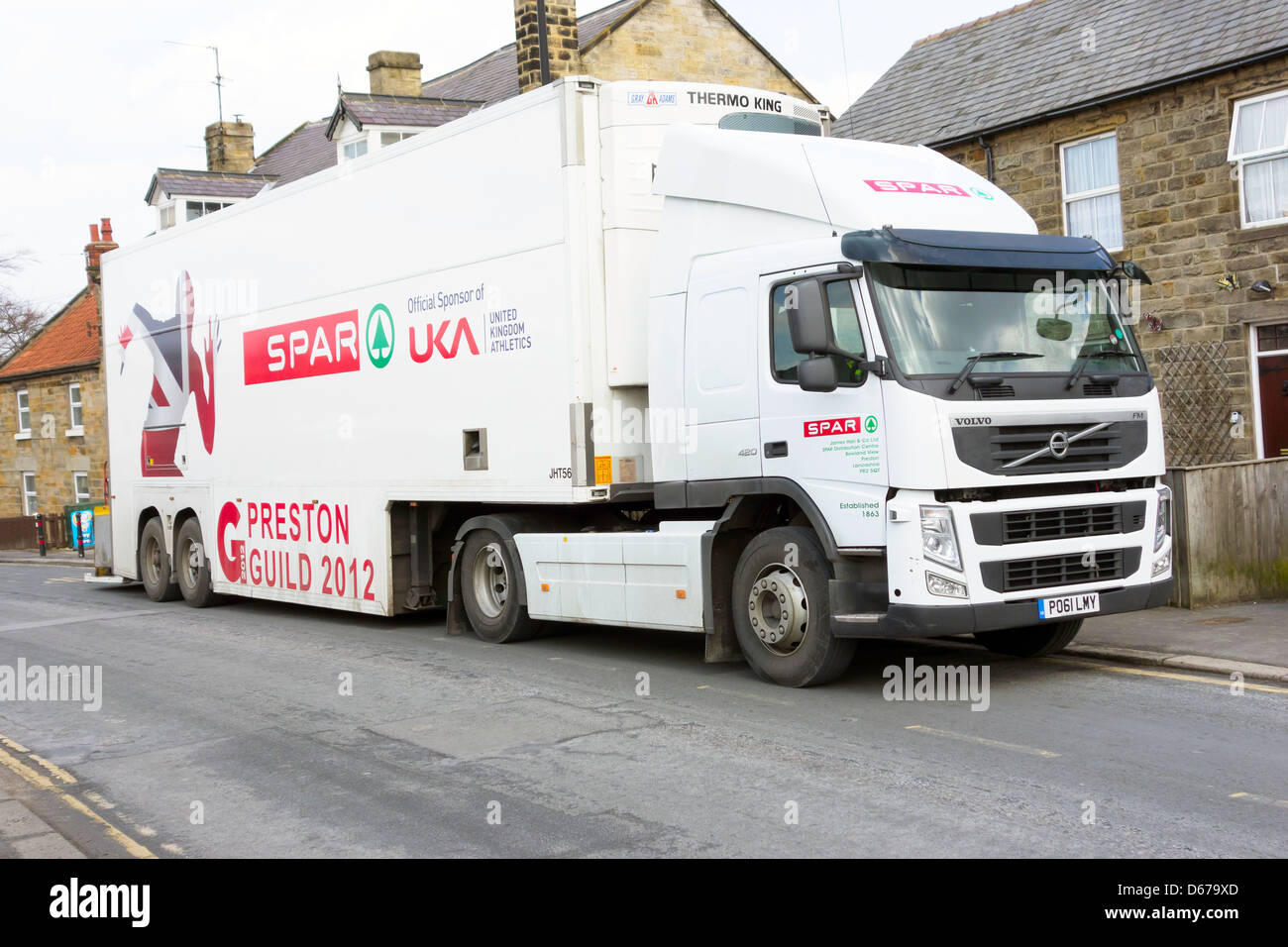 Very large lorry delivering goods to a small rural Spar franchise shop Stock Photo