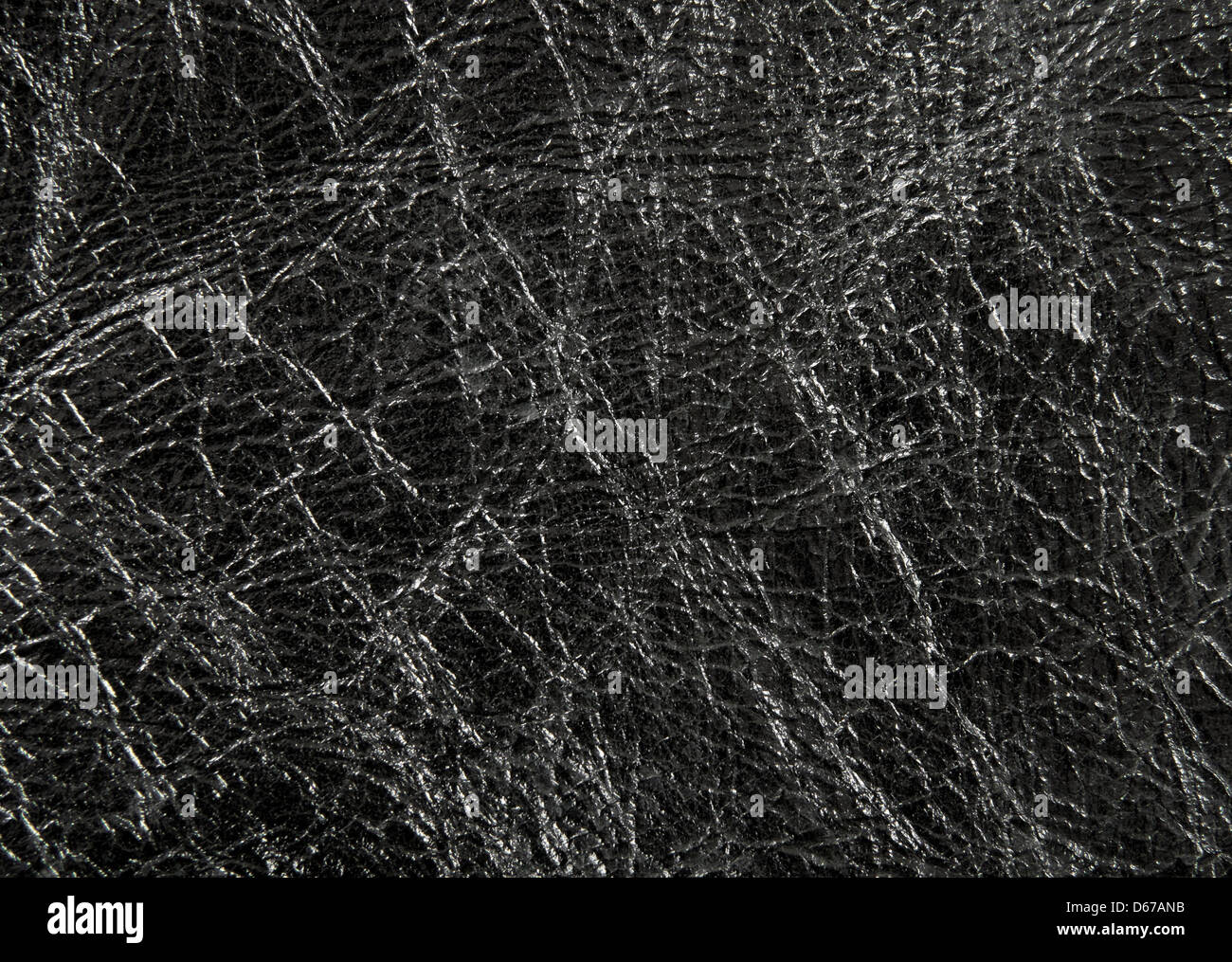 Closeup of shiny and wrinkled black leather texture. Stock Photo
