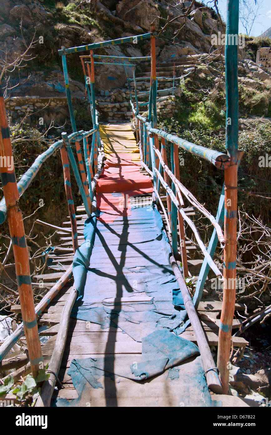 Rickety old wooden bridge over the river in the Ourika Valley, Morocco. Stock Photo