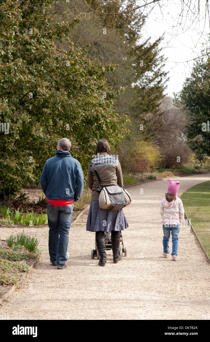 A family walking in the park, mother father and child seen from the rear, UK Stock Photo