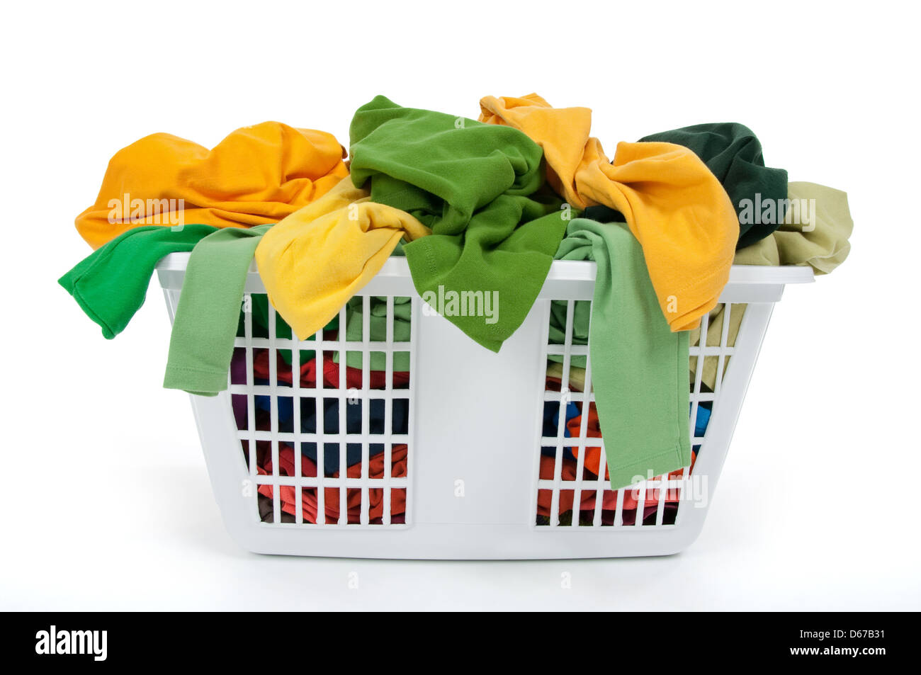 Colorful clothes in a laundry basket on white background. Green, yellow. Stock Photo