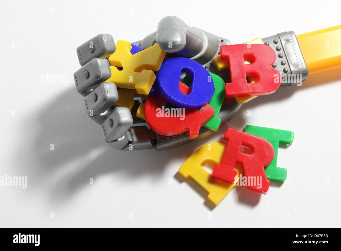 Toy Robot Hand with Plastic Alphabets Stock Photo