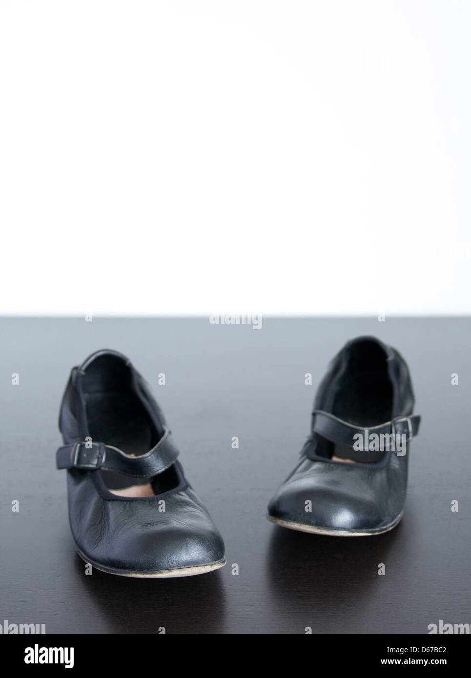 Black shoes on wooden surface, wish copy-space behind. Stock Photo