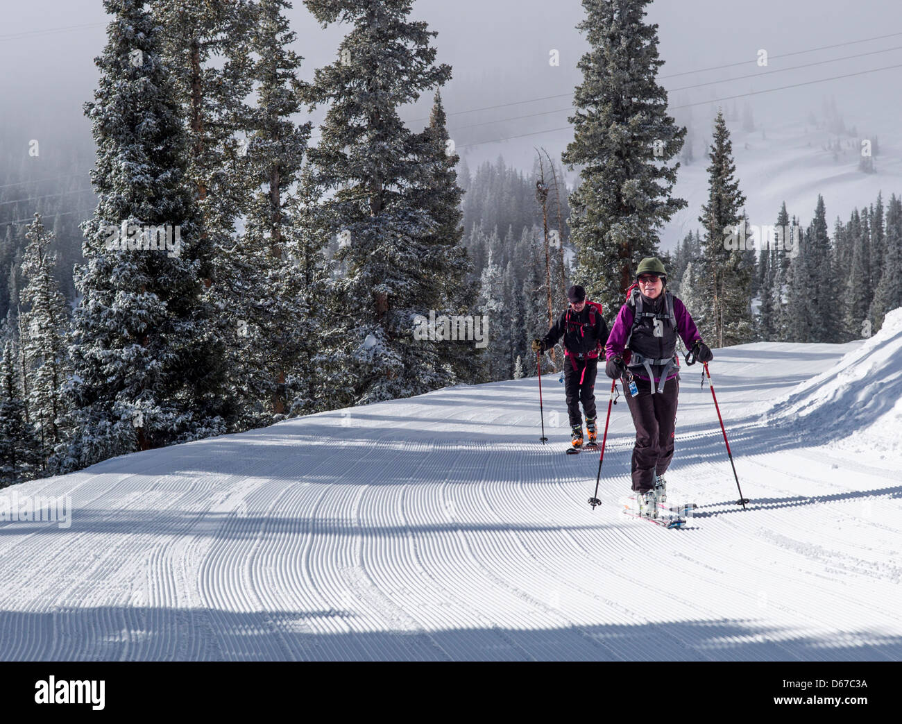 Man and woman skinning uphill on alpine touring skis at Monarch