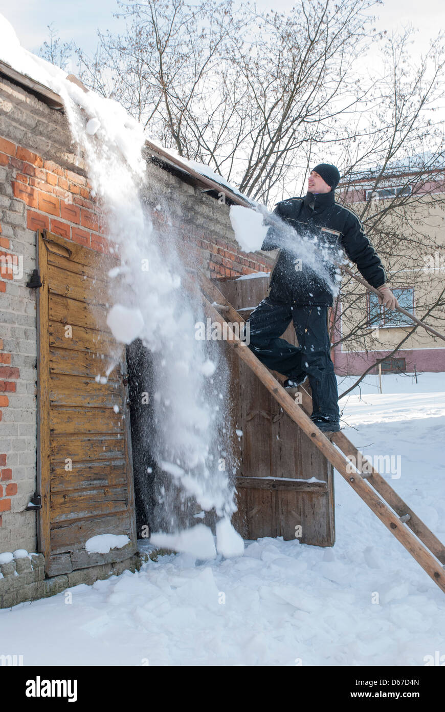 Man removing heavy snow from roof of building Stock Photo Alamy