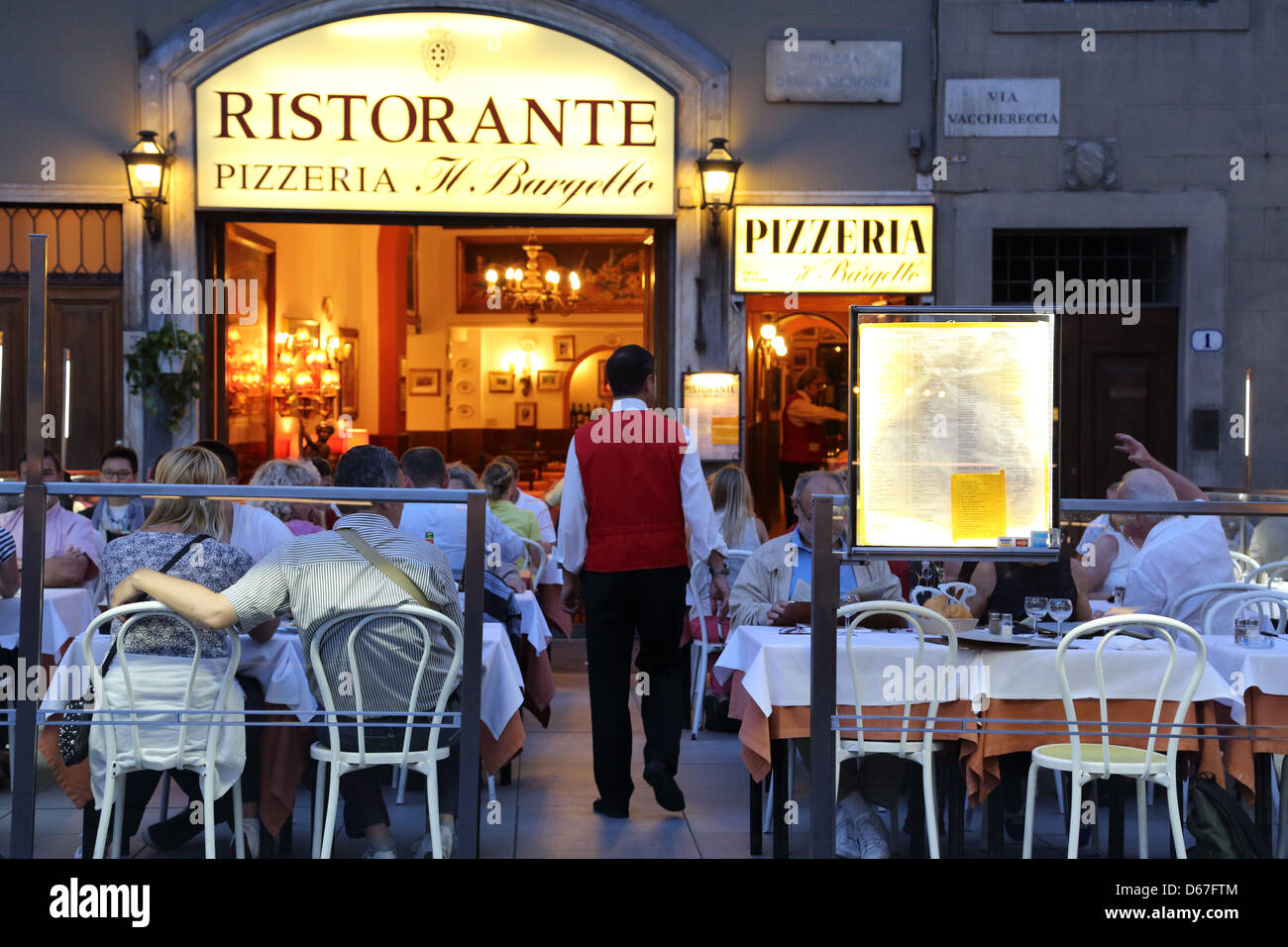 Restaurants at night in Piazza della Signoria Florence Italy. Palazzo Vecchio is nearby. Stock Photo