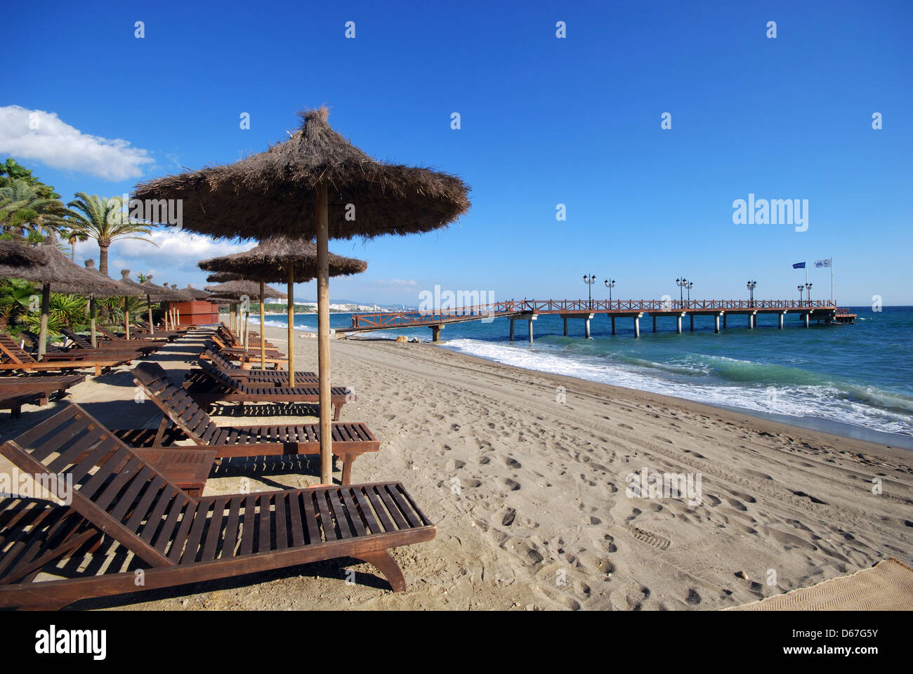 Empty sun beds and parasol on beach, Daitona Beach, Marbella, Costa del