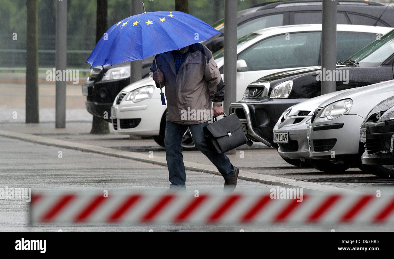An employee of the chancellery is pictured with a euro star umbrella at the chancellery in Berlin, Germany, 21 June 2012. The meeting of the coalition and the opposition with German chancellor Merkel takes place behind closed doors with the party and fraction heads of the Christian Democrats, the Liberal Party, the Social Democrats, the Green Party and the Left. Main topics discuss Stock Photo