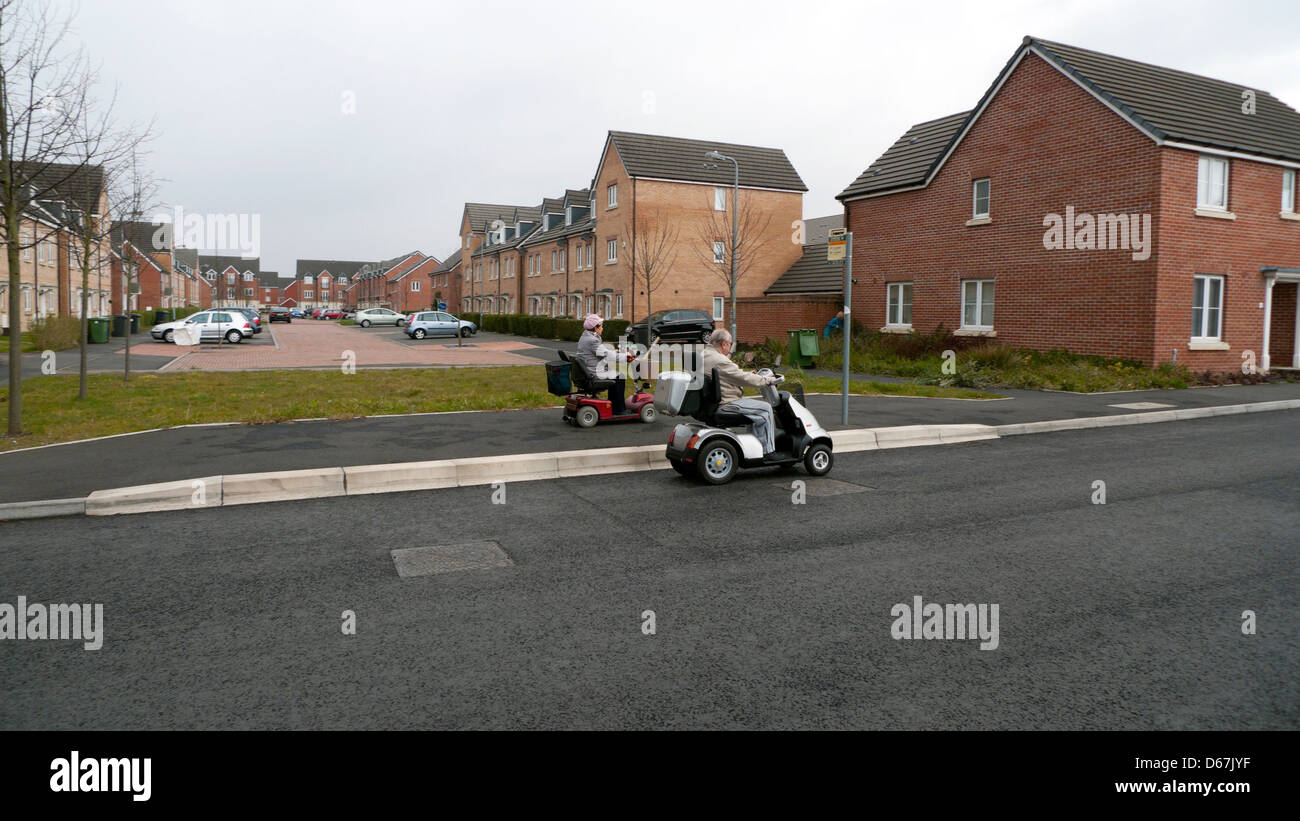 Old people person on mobility scooter drive past housing estere development Llanishen, Cardiff, Wales, UK KATHY DEWITT Stock Photo
