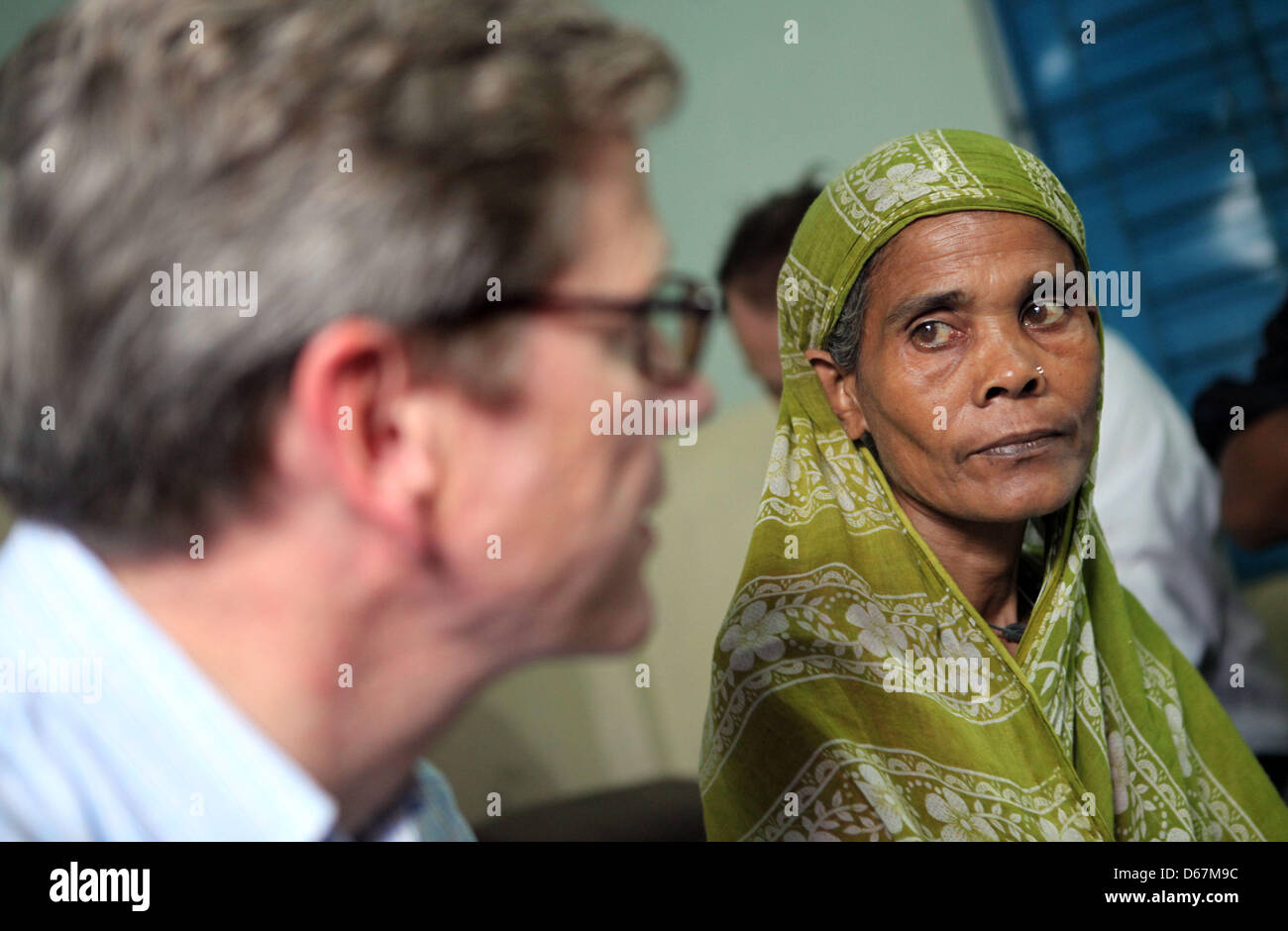 Bundesaußenminister Guido Westerwelle (FDP) sitzt neben einer unterernährten Patientin am Samstag (23.06.2012) in einer Arztpraxis der Hilfsorganisation 'Ärzte für die 3. Welt' im Slum von Korail in Dhaka (Bangladesch). Hier versorgen deutsche Ärzte ehrenamtlich die Bedürftigen. Foto: Jan Woitas dpa  +++(c) dpa - Bildfunk+++ Stock Photo