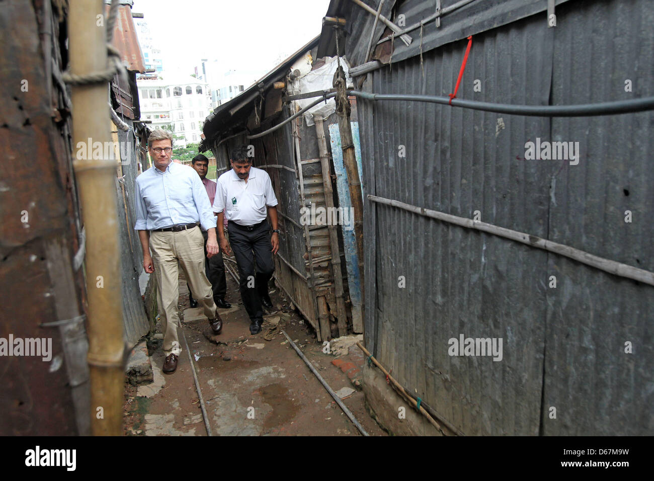 Bundesaußenminister Guido Westerwelle (FDP, M) besucht am Samstag (23.06.2012) den Slum von Korail in Dhaka (Bangladesch). Die Hilfsorganisation 'Ärzte für die 3. Welt' betreibt hier eine Schule und eine Arztpraxis, in der deutsche Ärzte ehrenamtlich die Bedürftigen versorgen. Foto: Jan Woitas dpa  +++(c) dpa - Bildfunk+++ Stock Photo