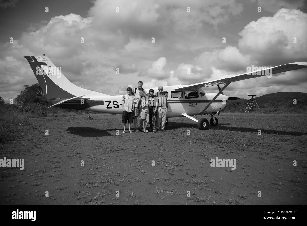 Family in front of a small plane in a game reserve Stock Photo