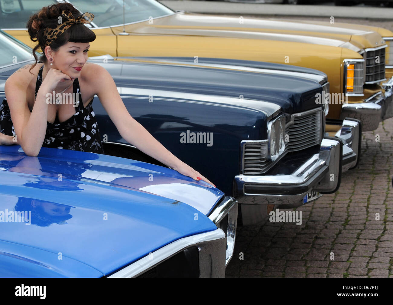 At a photocall for the 2nd annual US Car Convention, models pose with  classic American cars at Theaterplatz in Dresden, Germany, 26 June 2012.  From 13 until 15 July 2012, lovers of
