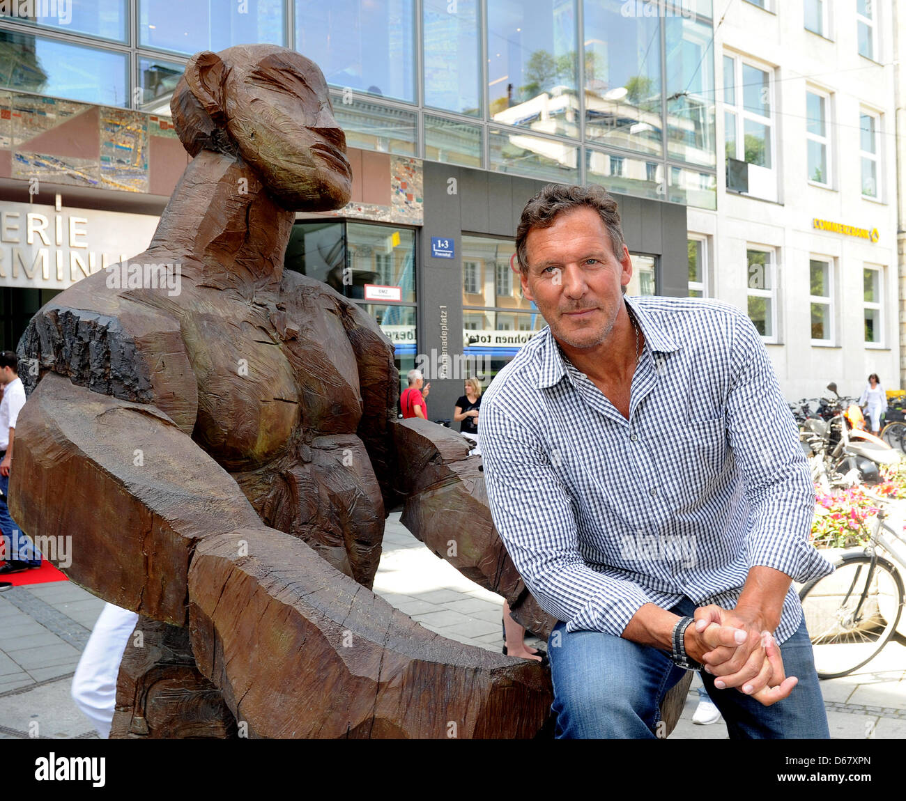 The actor Ralf Moeller sits on a sculptur during the summer festival of