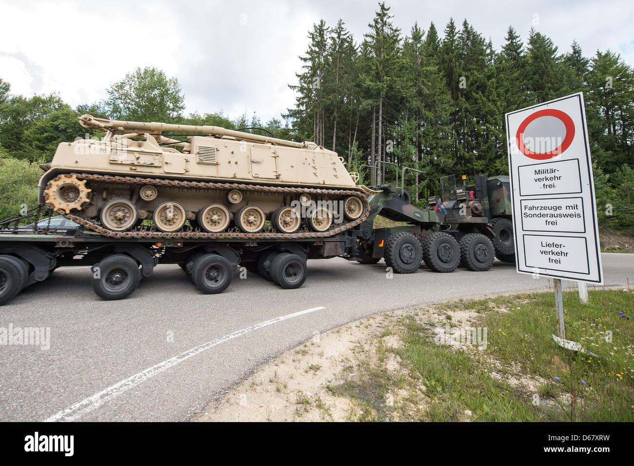 A tank is transported on a truck on the premises of the military