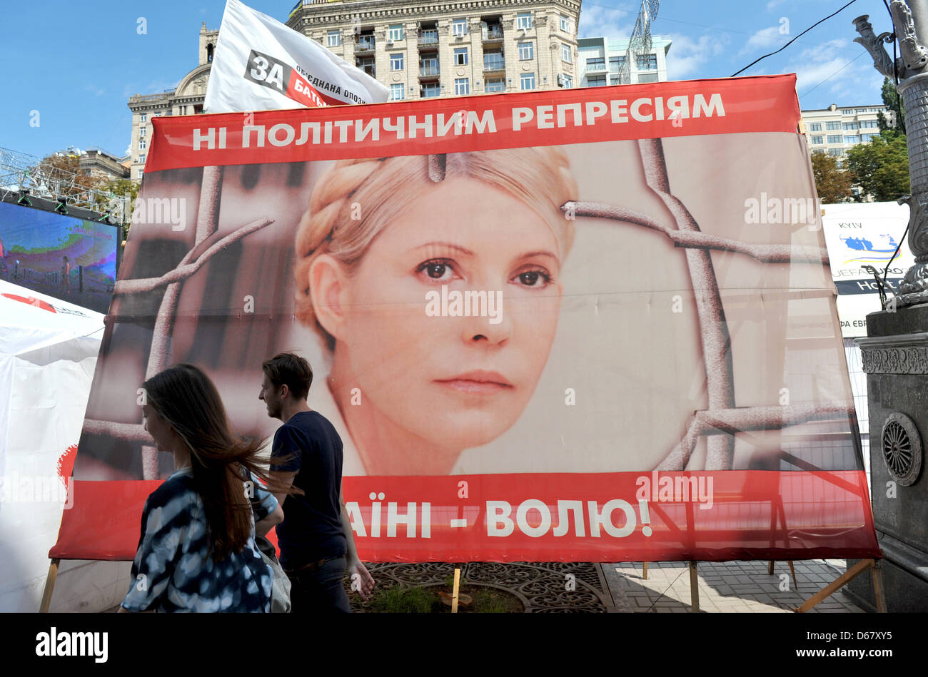 People walk past a placard of the Ukranian politician Yulia Tymoshenko in a protest camp in downtown Kiev, Ukraine, 30 June 2012. The Euro 2012 championships were discussed controversially over the case of Ukraine's jailed former Prime Minister Yulia Tymoshenko. Photo: ANDREAS GEBERT Stock Photo