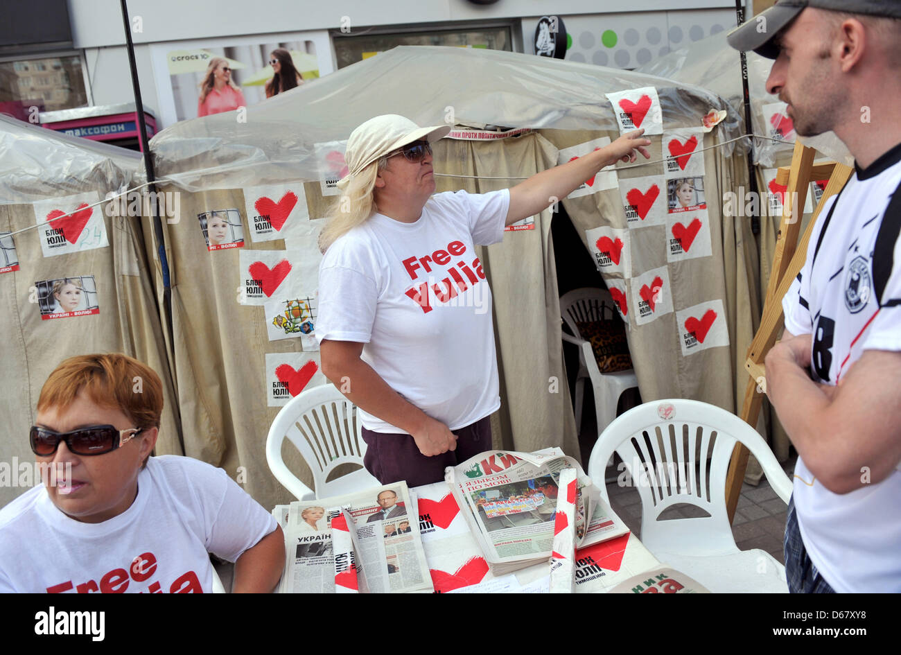 An activist stands in front of photos of the Ukranian politician Yulia Tymoshenko in a protest camp in downtown Kiev, Ukraine, 30 June 2012. The Euro 2012 championships were discussed controversially over the case of Ukraine's jailed former Prime Minister Yulia Tymoshenko. Photo: ANDREAS GEBERT Stock Photo