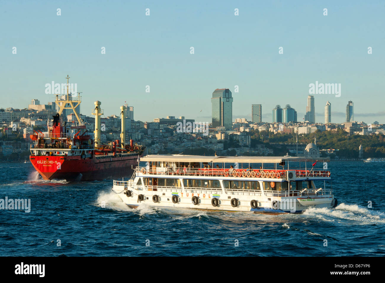 Türkei, Istanbul, Fährschiff und Frachter auf dem Bosporus im Hintergrund die HochHäuser von Levent Stock Photo