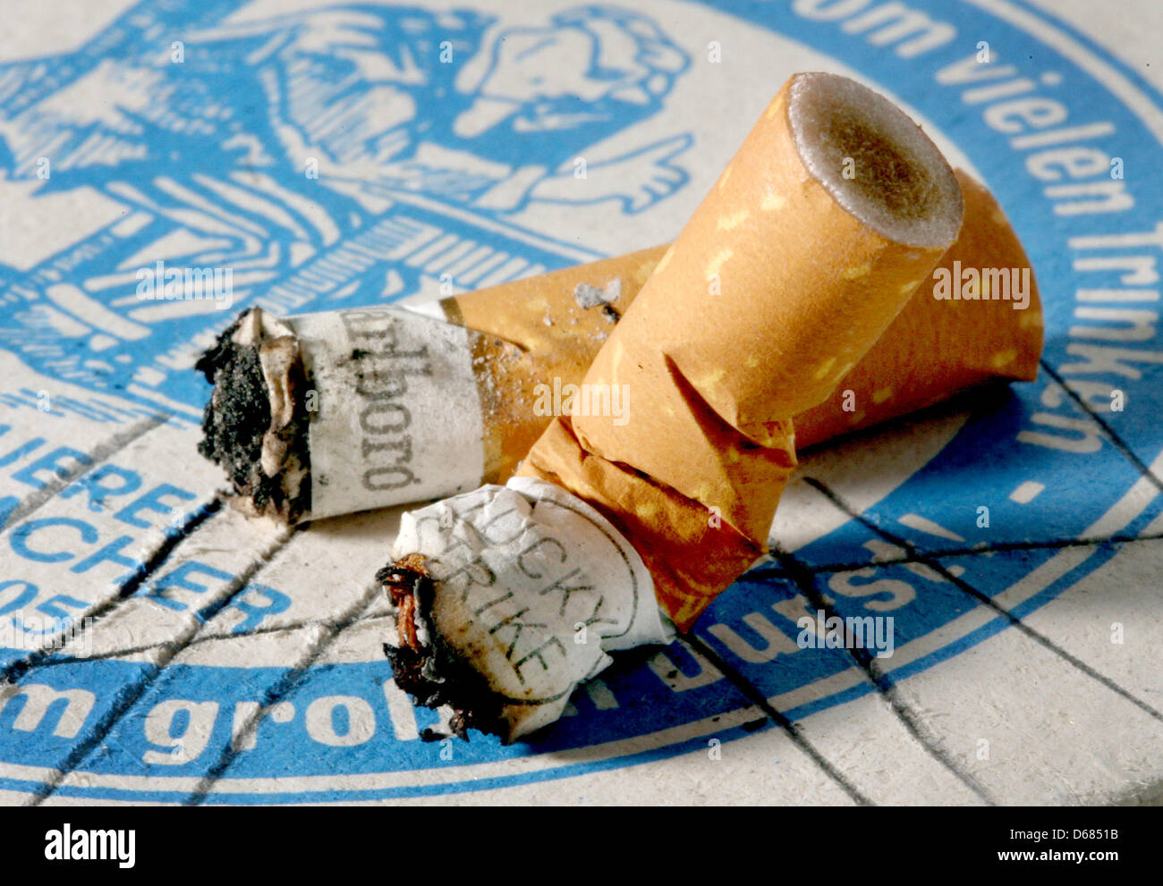 (dpa file)- A file picture dated 24 May 2008 shows cigarette buds lying on a beermat in Duesseldorf, Germany. The SPD party and Alliance '90/The Greens proposed a non-smoker protection law at the parliament of North Rhine-Westphalia on 04 July 2012. Photo: Martin Gerten Stock Photo