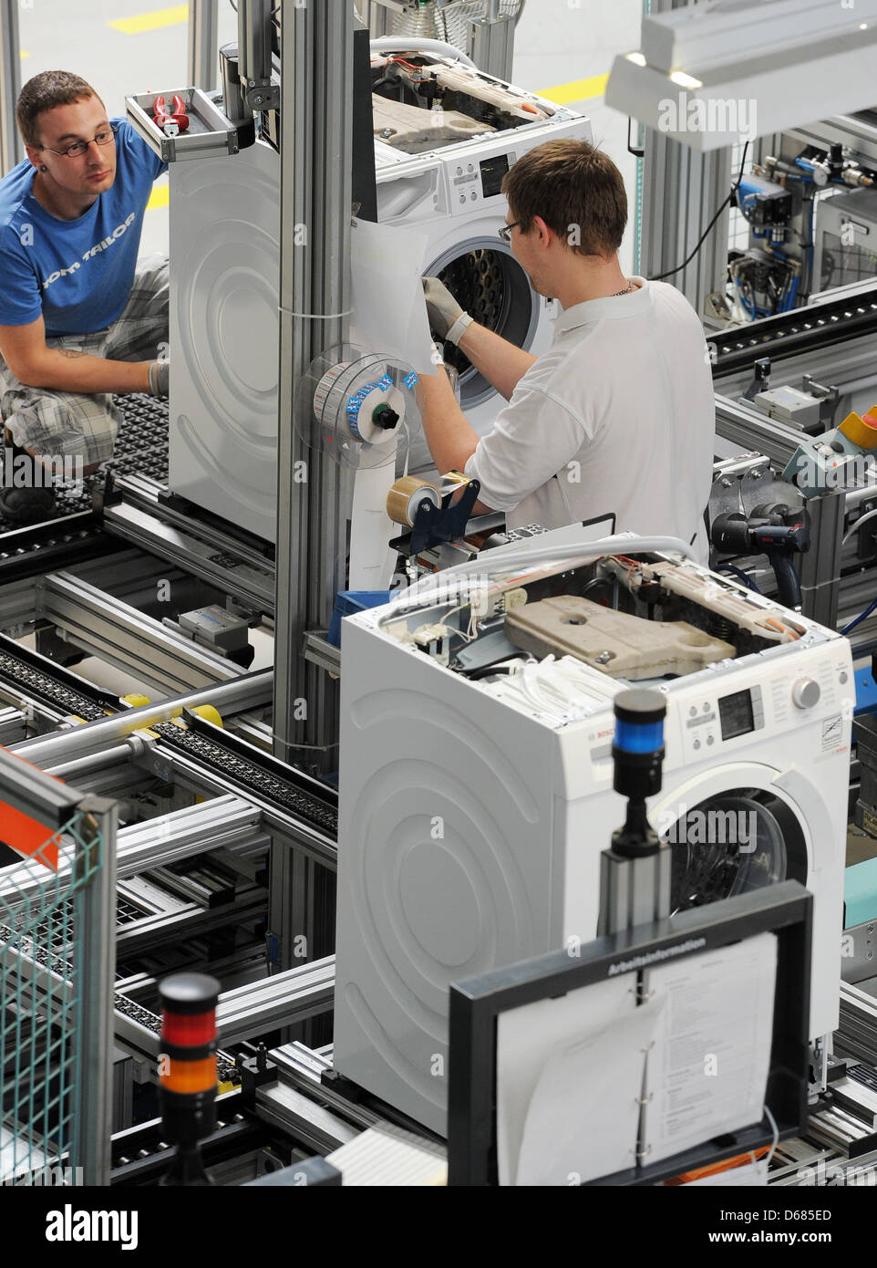 Workers of Bosch Siemens Hausgeraete GmbH assemble washing machines in Nauen, Germany, 4 July 2012. About 600 employees produce approximately 800,000 premium-quality washing machines annually, of which two thirds are exported. BSH Bosch Siemens Hausgeraete GmbH is one of the leading home appliance manufacturer worldwide and the sector's largest company in Europe. Photo: Bernd Settn Stock Photo