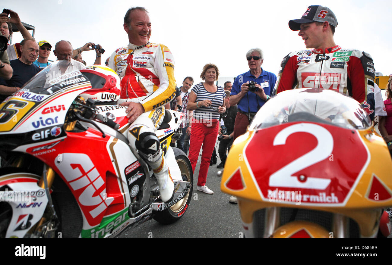 German motorcycle racers Helmut (L) and Stefan Bradl have switched motorcycles after a short drive on the Sachsenring racing track near Hohenstein-Ernstthal, Germany, 05 July 2012. Helmut Bradl became vice world champion on a 250cc Honda in 1991, his son will ride a 1000cc Honda in the MotoGP. The Germany Grand Prix will be held on the 85th anniversary of the Sachsenring on 07 and  Stock Photo