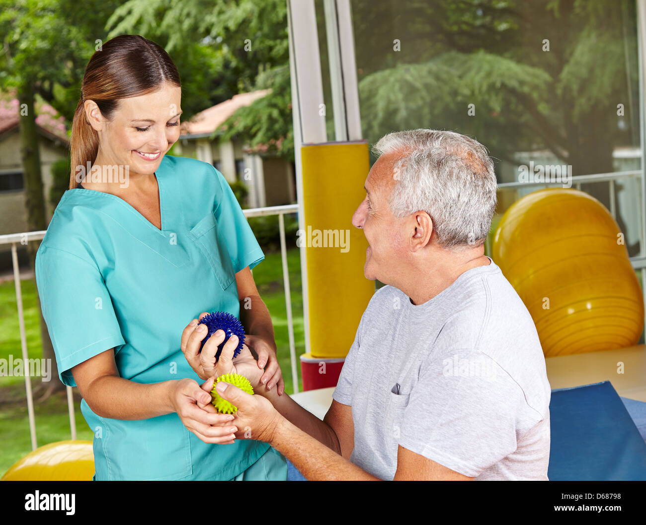 Senior man doing exercises with spikey balls at physiotherapy Stock Photo