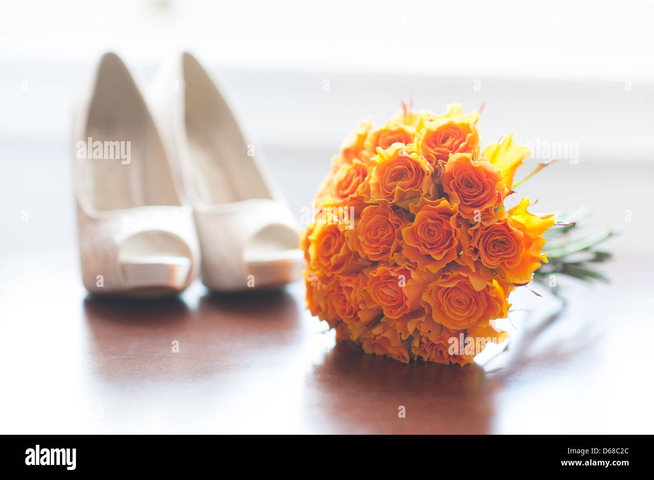 wedding shoes and bouquet of orange roses nobody Stock Photo