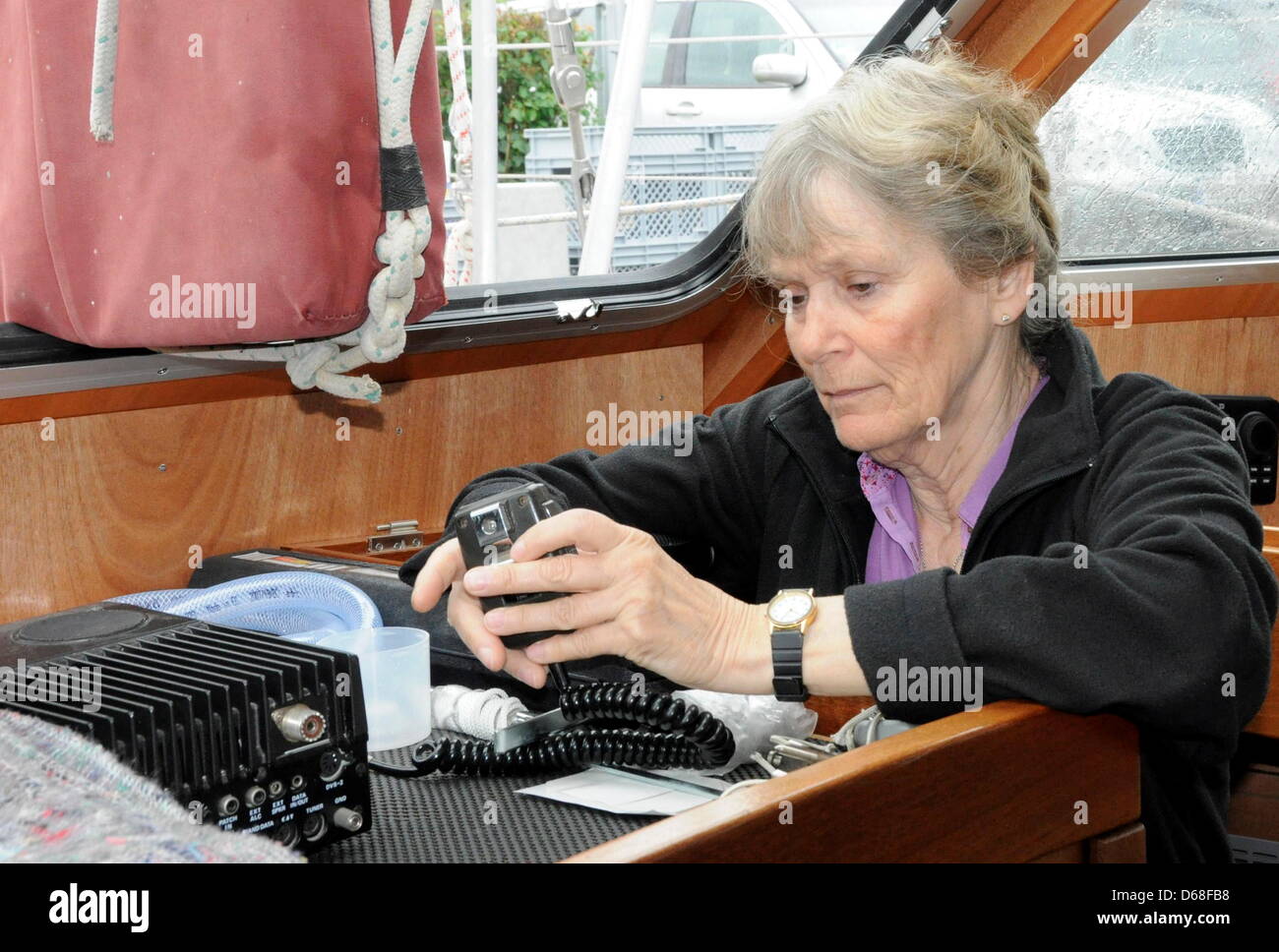 70-year-old globetrotter Heide Wilts examins a mobile radio transmitter on her 16 metre long yacht 'Freydis III' at the harbour of Leer, Germany, 10 July 2012. Photo: Hans-Christian Woeste Stock Photo