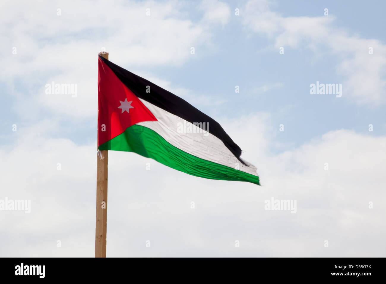 Flag of Jordan, flying against a sky with clouds Stock Photo Alamy