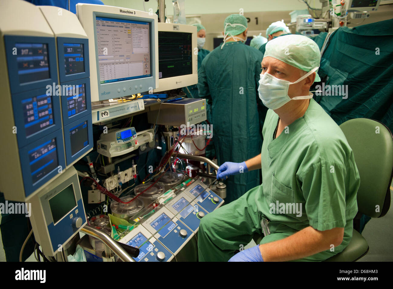 A doctor checks a breathing machine during an operation on a patient's heart at the German Heart Institute in Berlin, Gewrmany, 12 July 2012. Since 1987 more than 70,000 open-heart surgeries have been performed here. Photo: Maurizio Gambarini Stock Photo