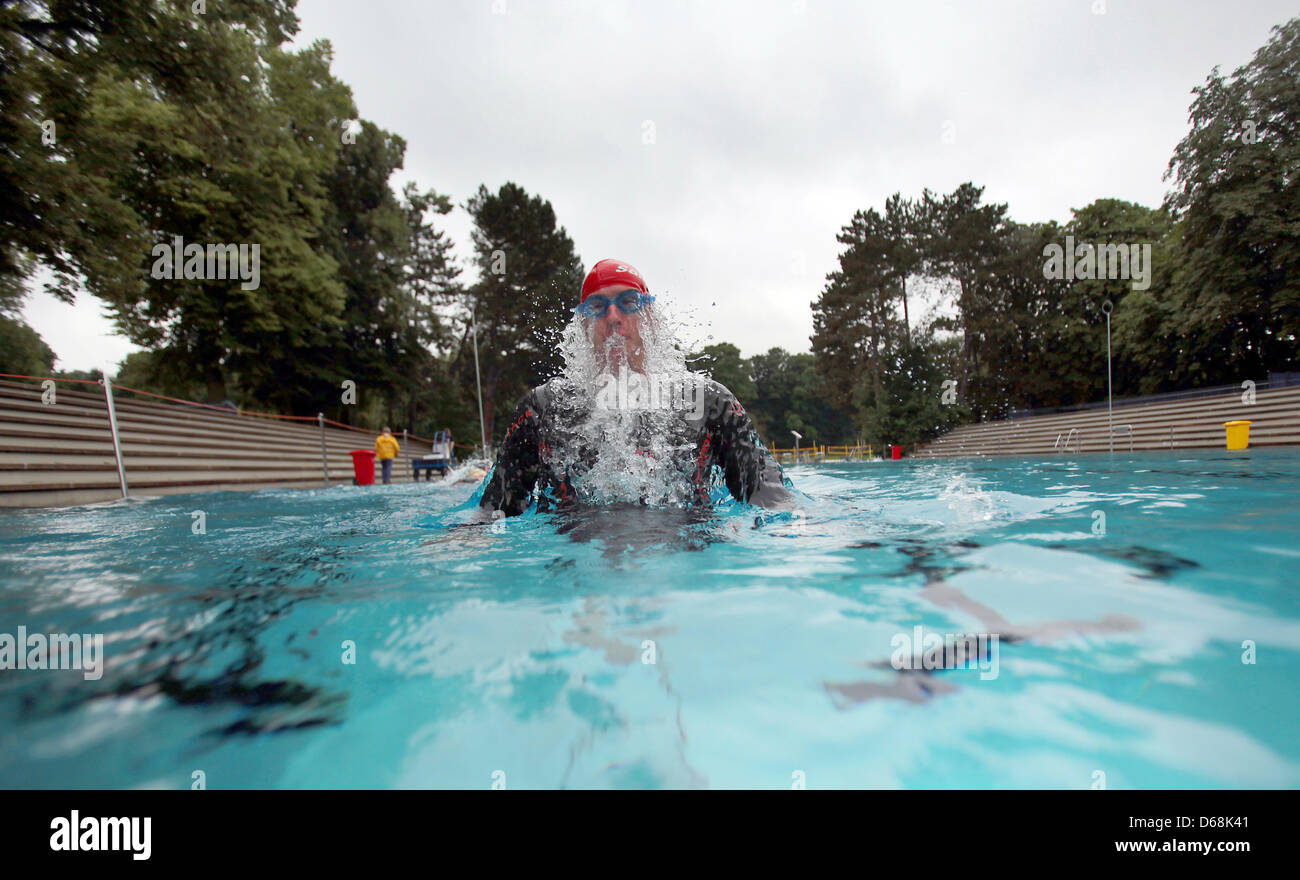 A swimmer in a wetsuit swims in an openair swimming pool in Cologne