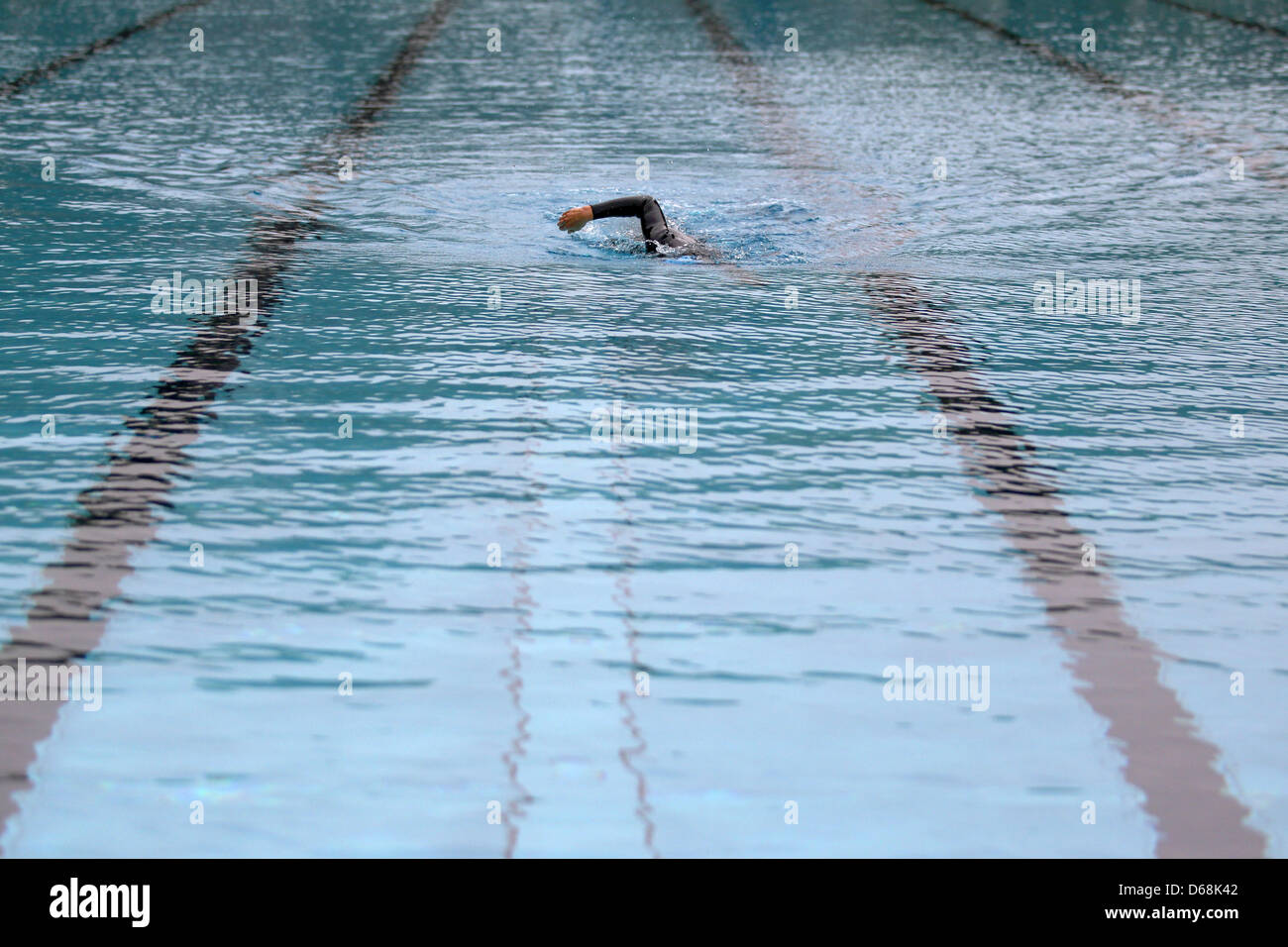 A swimmer in a wetsuit swims in an openair swimming pool in Cologne