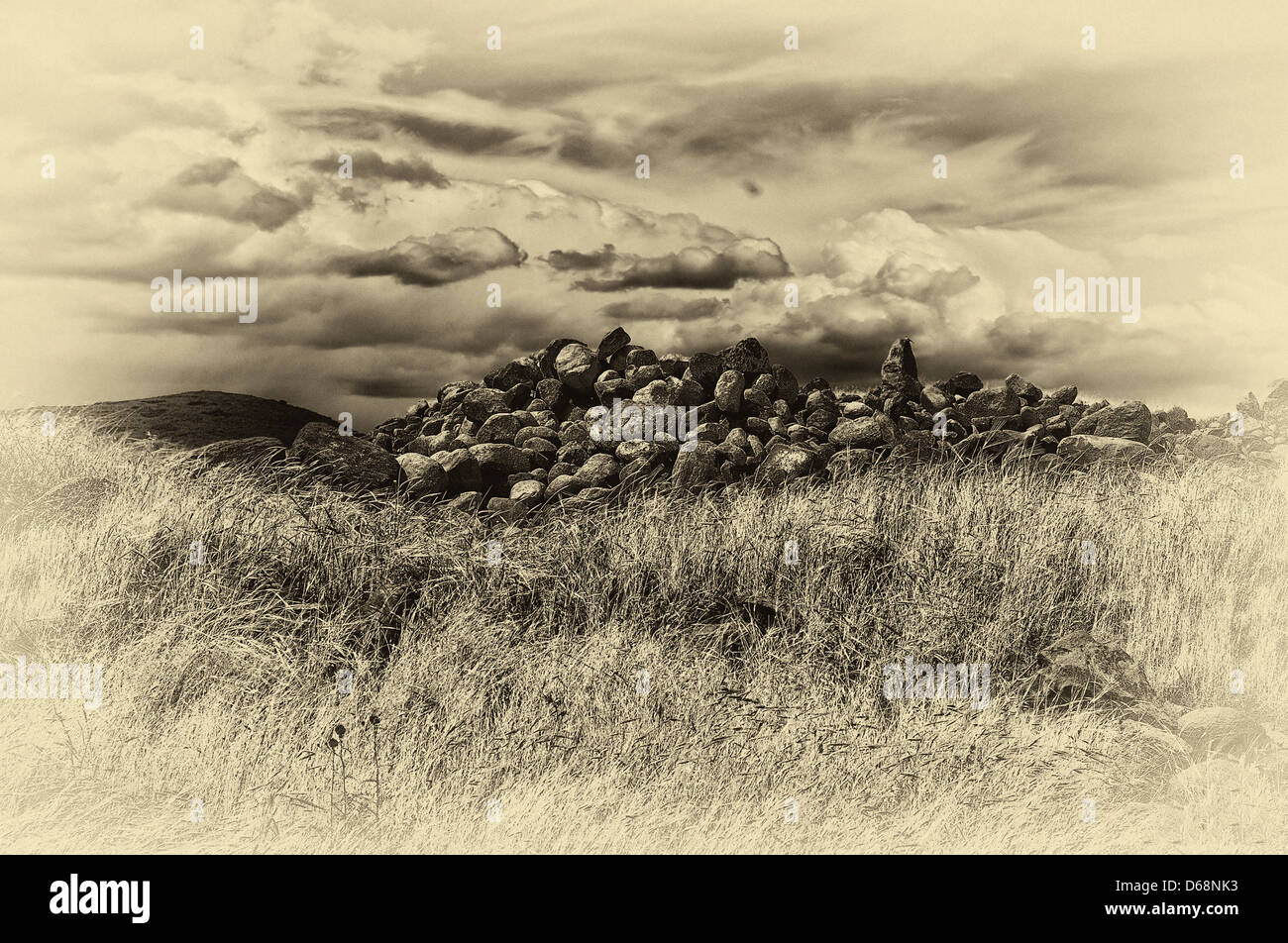 Digitally manipulated image of stones in a field with dramatic sky Stock Photo