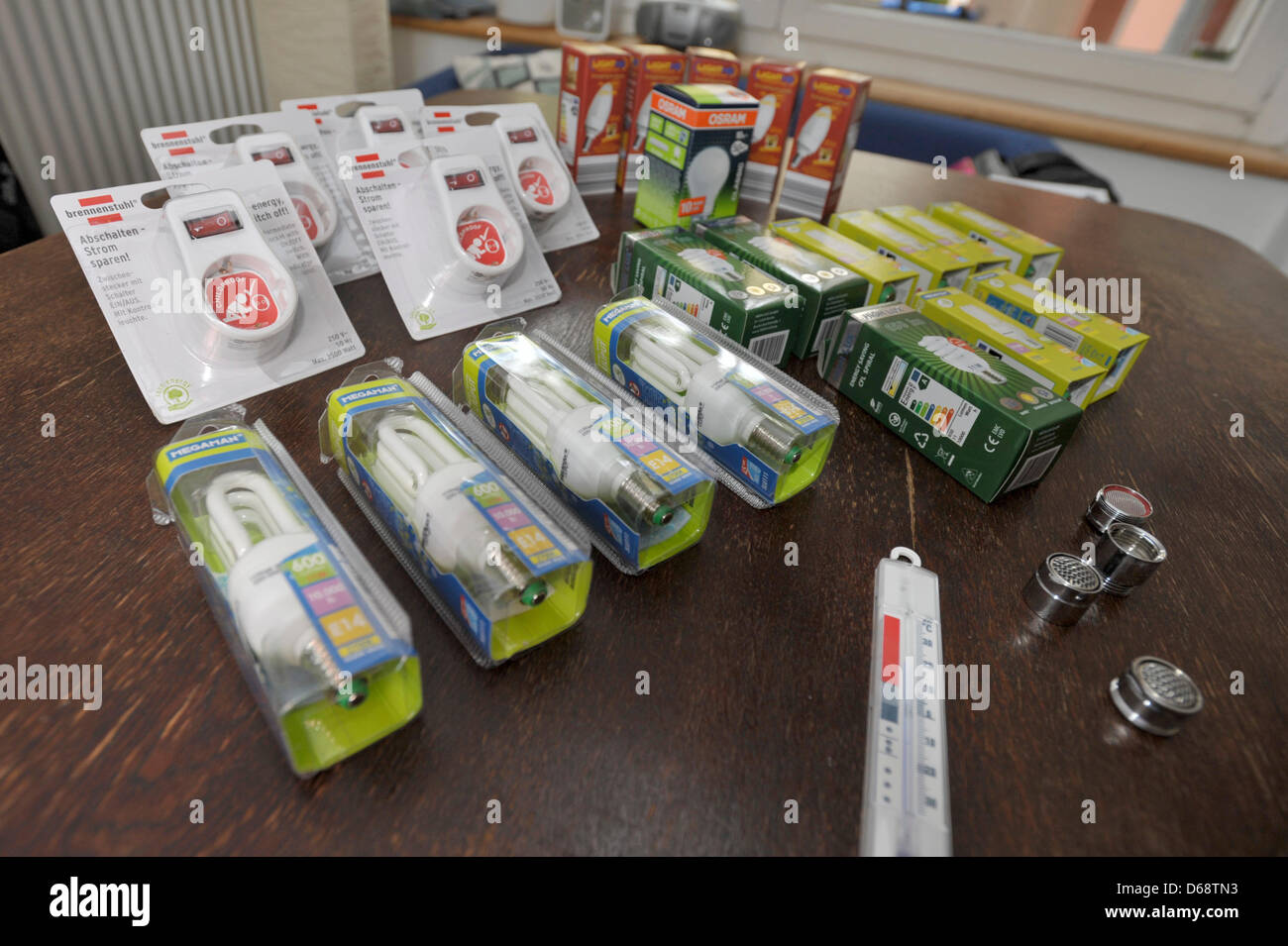 Energy saving devices lie on a table in a flat in Berlin, Germany, 18 July 2012. Campaign Electricity Saving Check wants to lower energy consumption in low-income households to ease the burden of costs. Long-term unemployed also get the chance to attempt reentering the job market via their work as an electricity-saving helper. Photo: Markus Heine Stock Photo