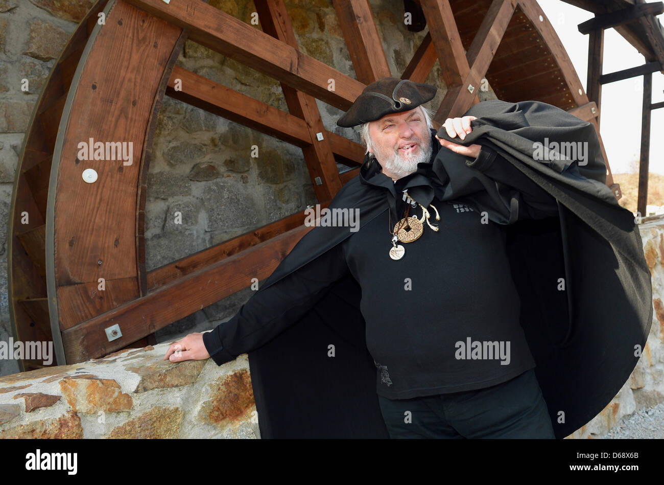 The black miller aka Dieter Klimek stands in front of the mill wheel at the Krabat adventure farm in the Hoyerswerda district Schwarzkollm, Germany, 28 March 2012.  Krabat is a German fantasy novel by Otfried Preussler first published in 1971. It is the basis of different films, such as The Sorcerer's Apprentice and the 2008 live-action film Krabat. Photo: Britta Pedersen Stock Photo