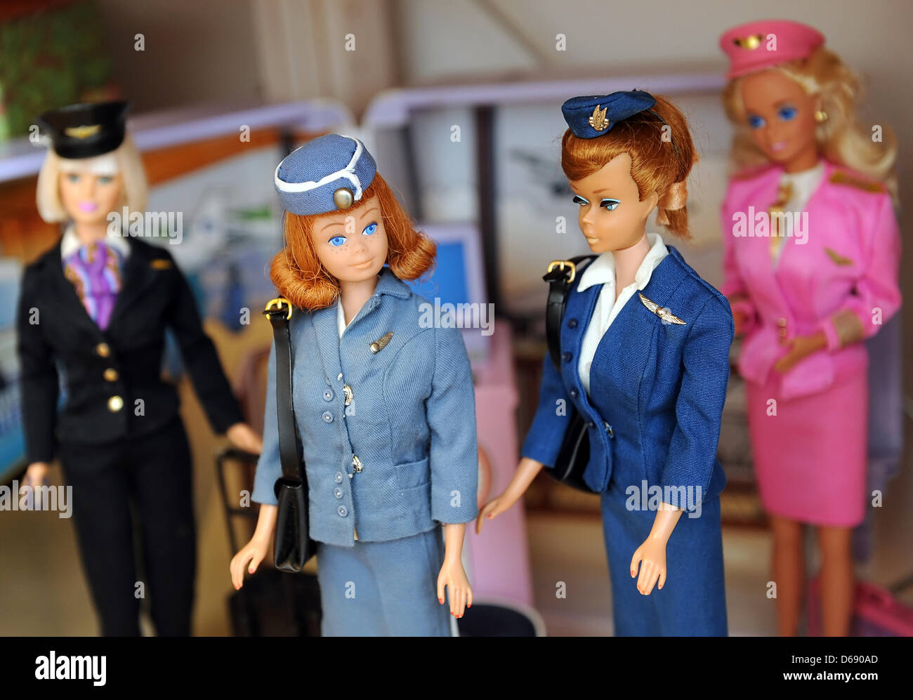 Flight Attendant Barbies and Pilot Barbie are on display at the city museum 'Alte Burg' in Wittenberge, Germany, 26 January 2012. The tavelling exhibition 'Busy Girl - Barbie's Career' documents women's history of the last 50 years with the help of Barbie dolls. They show the development Barbie as a homemmaker to Barbie as a business woman, showing how Barbie always seems to embody Stock Photo