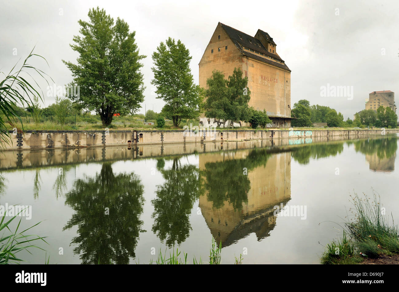 The old grain storage and warehouse buildings still stand in Lindenau Harbour in Leipzig, Germany, 05 July 2012. The complex built in 1938 was to receive two handling docks each with a length of 1000 meters, 90 meters wide and six meters deep as well as two industrial harbours north of the docks, but construction halted in 1943. The buildings were still in use up until the 1990's b Stock Photo