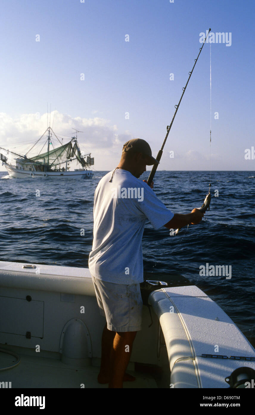 Man fishing for king mackerel near a shrimp boat in the Gulf of Mexico