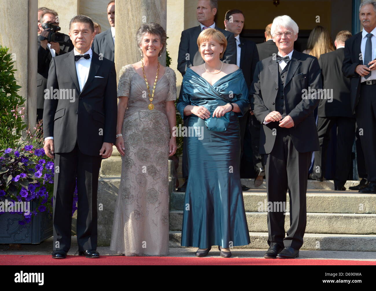 German Chancellor Angela Merkel (CDU, 2.v.r.) and her husband Joachim Sauer (l) Brigitte Merk-Erbe (FW, 2.v.l.), mayor of Bayreuth, and her husband Thomas Erbe (r) arrive at the opening of the Bayreuth Festival 2012 in Bayreuth, Germany, 25 July 2012. The one-month festival is Germany's most prestigious culture event. Photo: Tobias Hase dpa/lby Stock Photo