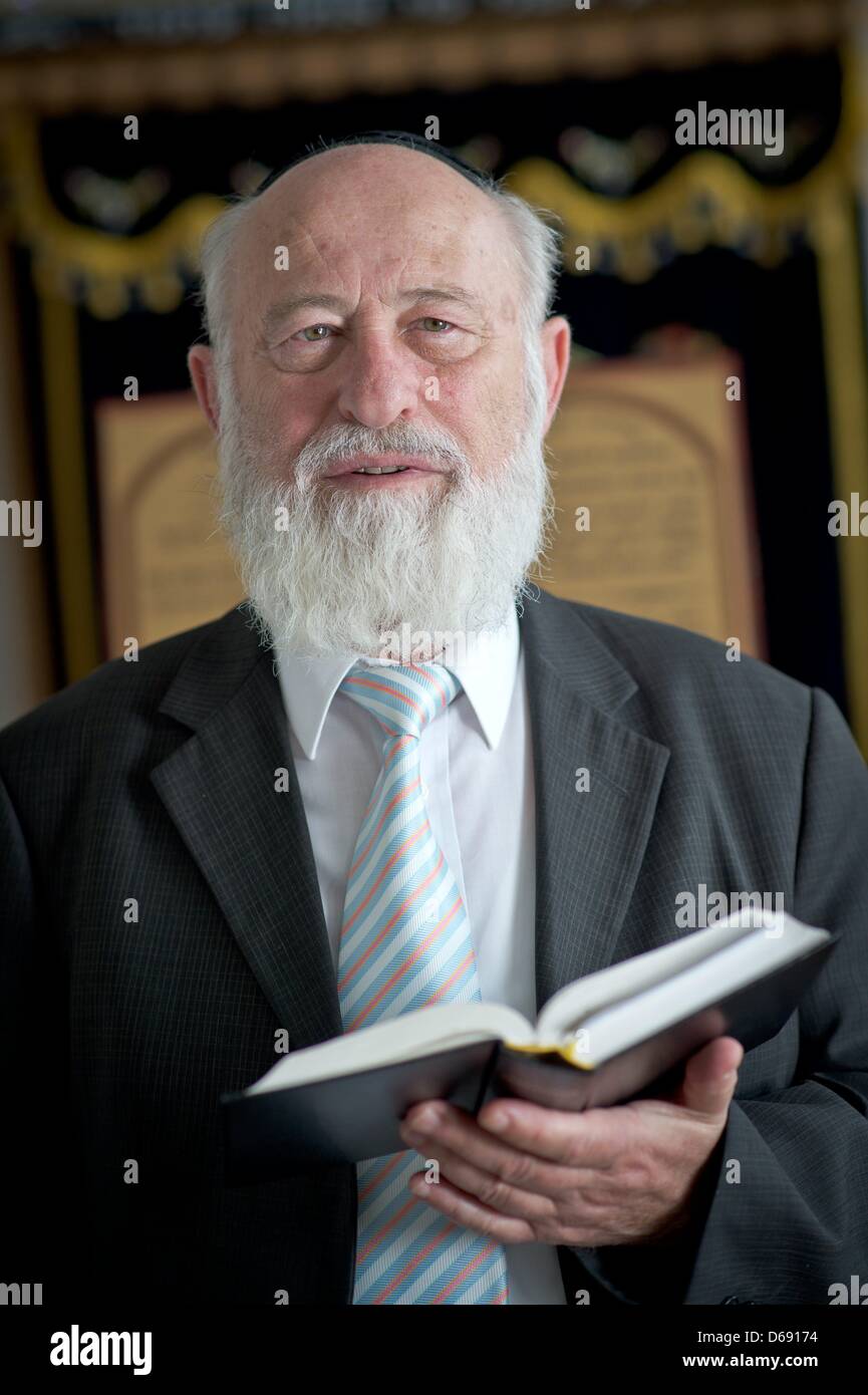 Rabbi David Goldberg holds a copy of the Old Testament in a room of the Israeli religious community in Hof, Germany, 26 July 2012. Rabbi Goldberg acts as Mohel in the brit milah, the Jewish religious circumcision ceremony. Photo: David Ebener Stock Photo