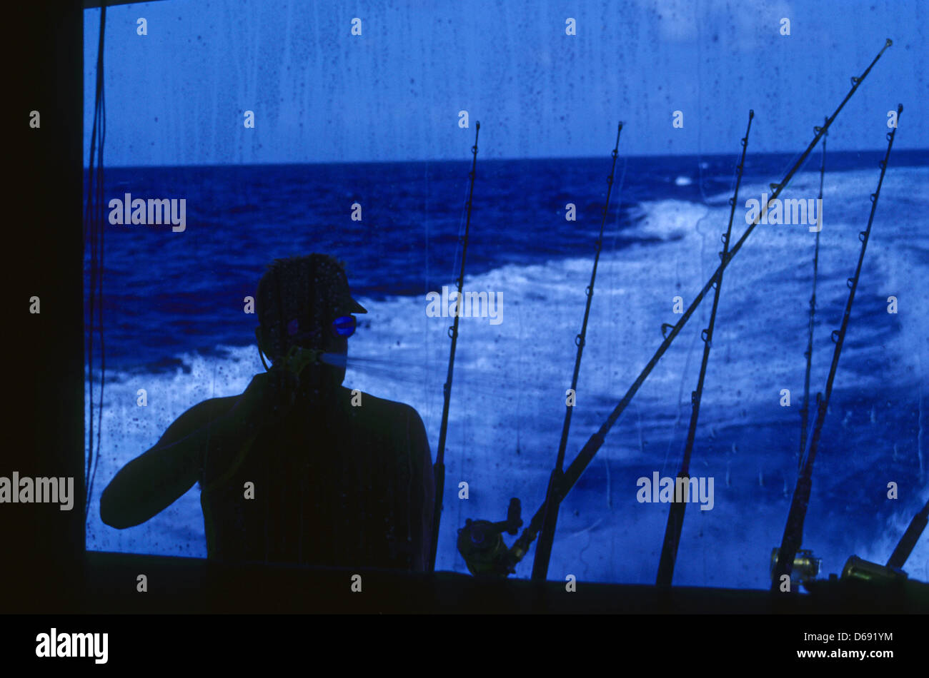 Deckhand washing down the boat after a day of fishing in the Gulf of