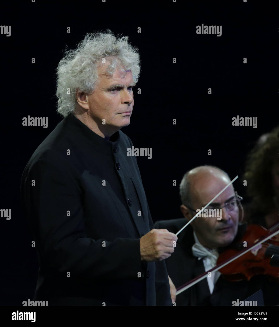 Sir Simon Rattle conducts the London Symphony Orchestra during the Opening Ceremony of the