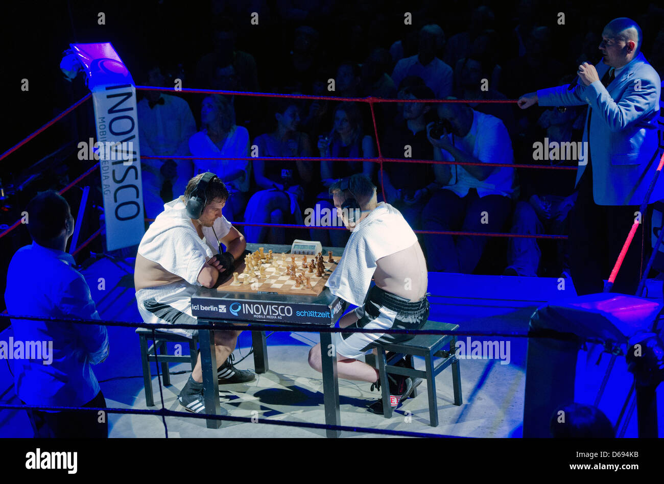 Chess boxers Arik Braun (R) and Felix Bartels sit in front of a chequer  board during the Chess Boxing Championships in Berlin, Germany, 28 July  2012. The chess boxing event took place