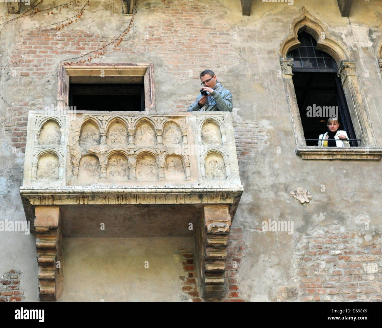 A tourist takes a picture from the balcony on which Juliet from Shakespeatre's Romeo and Juliet is supposed to have stood in the inner courtyard of Casa die Giulietta in Verona, Italy, 21 April 2012. Photo: Britta Pedersen Stock Photo
